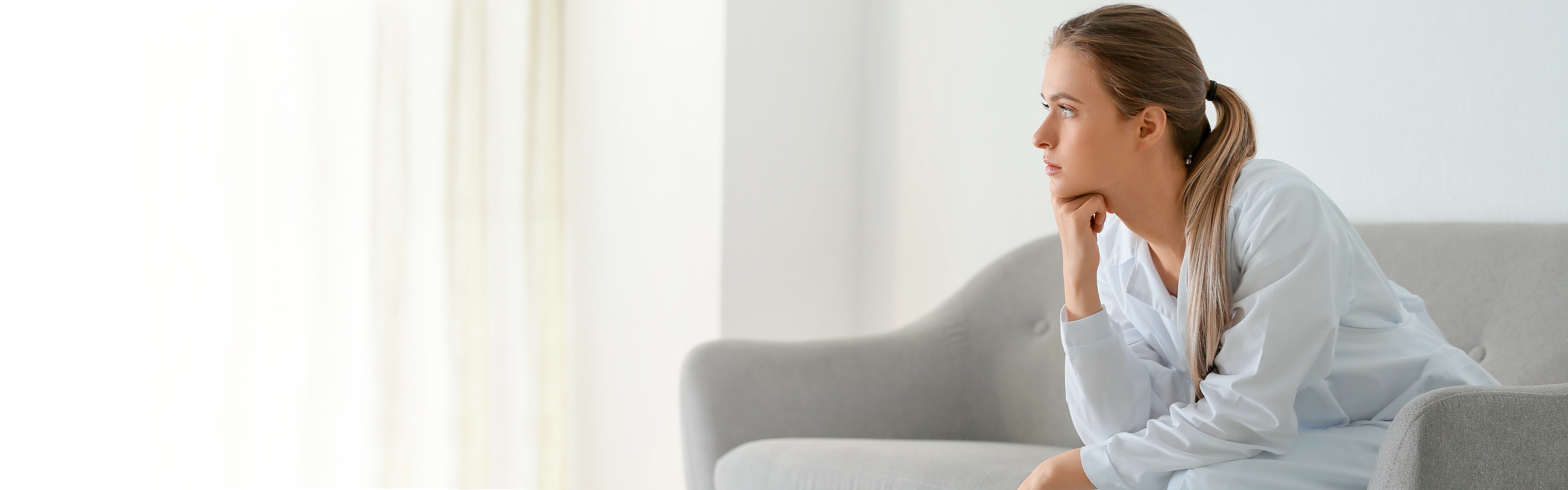 Sad and stressed woman sitting on a sofa