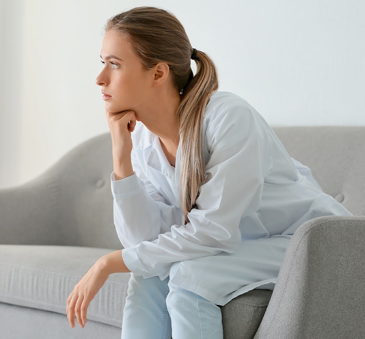 Sad and stressed woman sitting on a sofa
